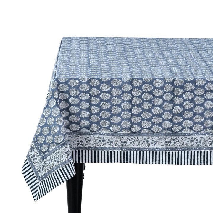 blue and white decorative cotton tablecloth with striped border on wooden table