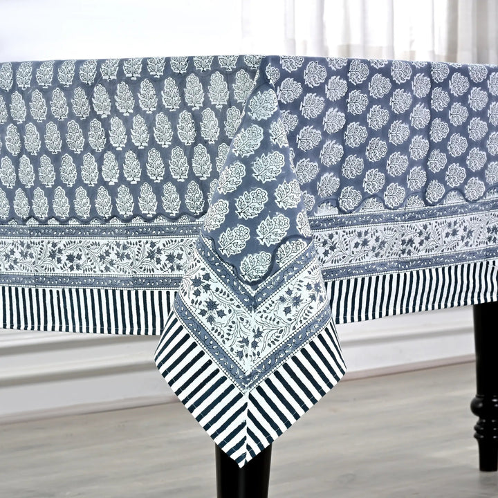 blue and white decorative cotton tablecloth with striped border on wooden table