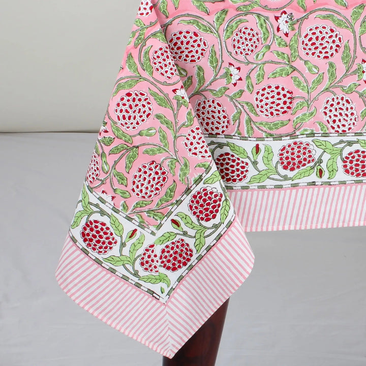 pink decorative tablecloth with striped border on wooden