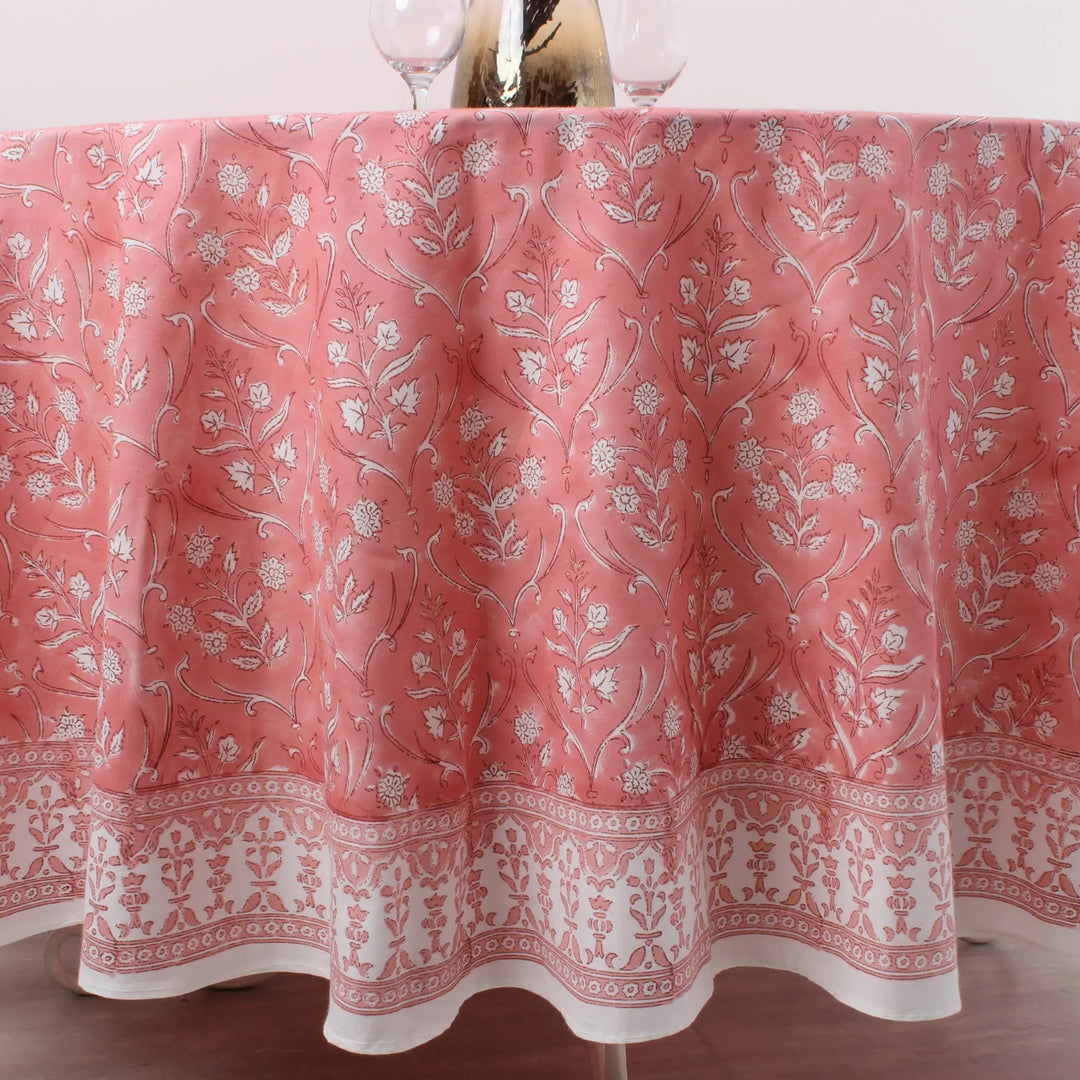 Pink floral patterned tablecloth on a table with glasses.