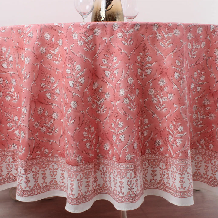 Pink floral patterned tablecloth on a table with glasses.