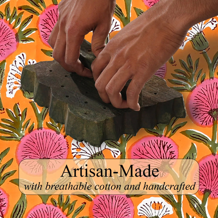 Hands working with a green textile on an orange background with floral patterns and &