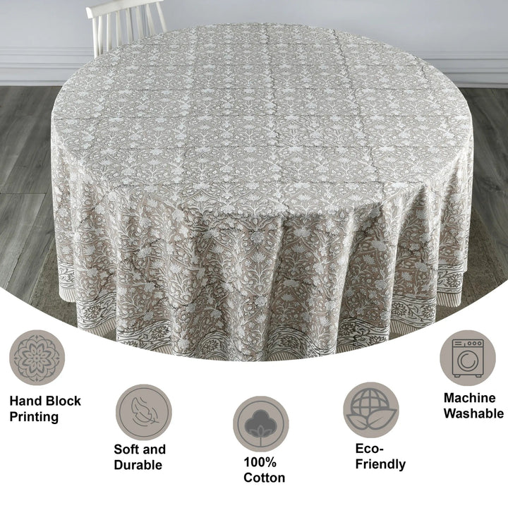Round tablecloth with floral pattern on a wooden floor, featuring icons and text about material and care.