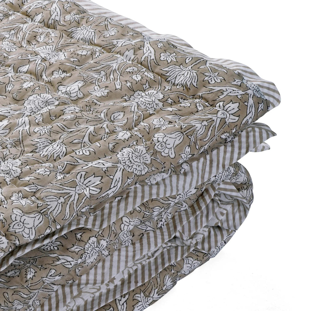 Stack of fabric sheets with floral and striped patterns on a white background