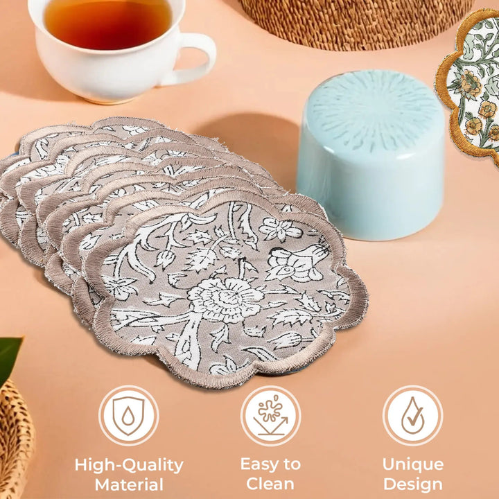 Set of floral lace coasters on a beige surface with a cup of tea and decorative items.