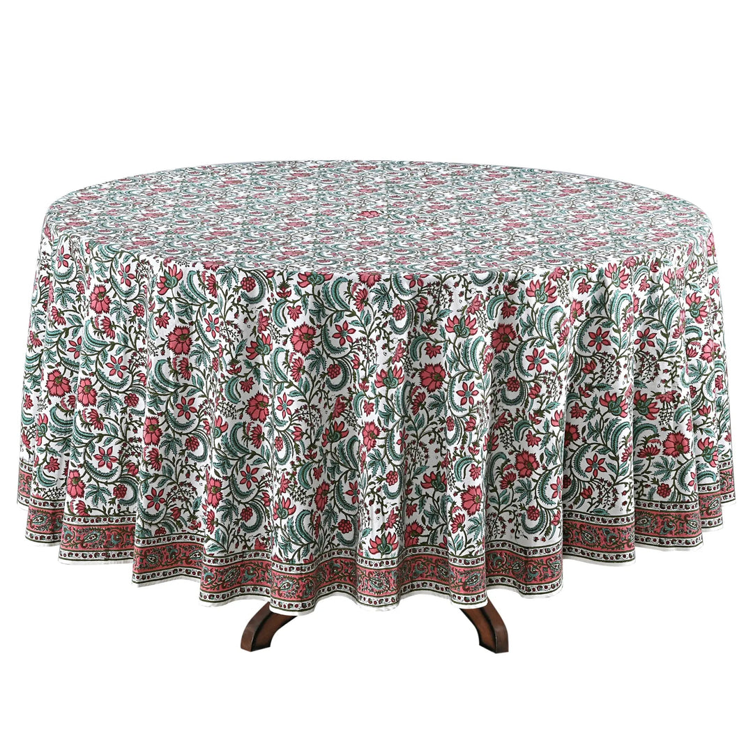 Round table with a floral patterned tablecloth on a white background