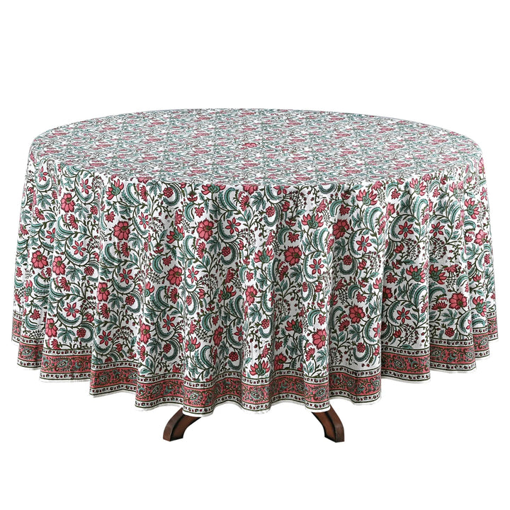 Round table with a floral patterned tablecloth on a white background