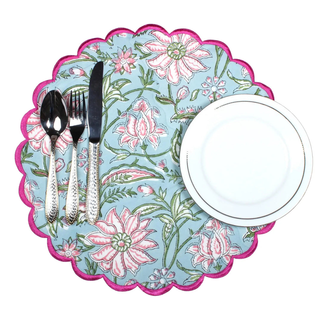 Floral-patterned placemat with cutlery and a plate on a white background