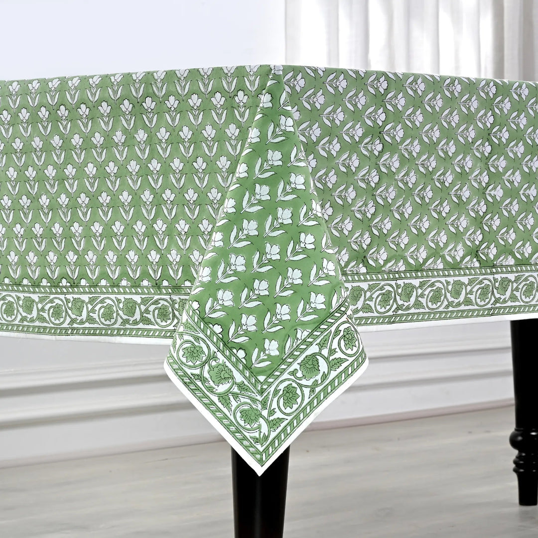 Green and white patterned tablecloth on a table with a white curtain background