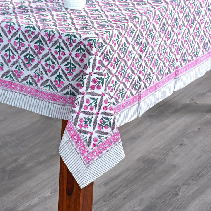 Patterned tablecloth on a wooden table with a gray floor background
