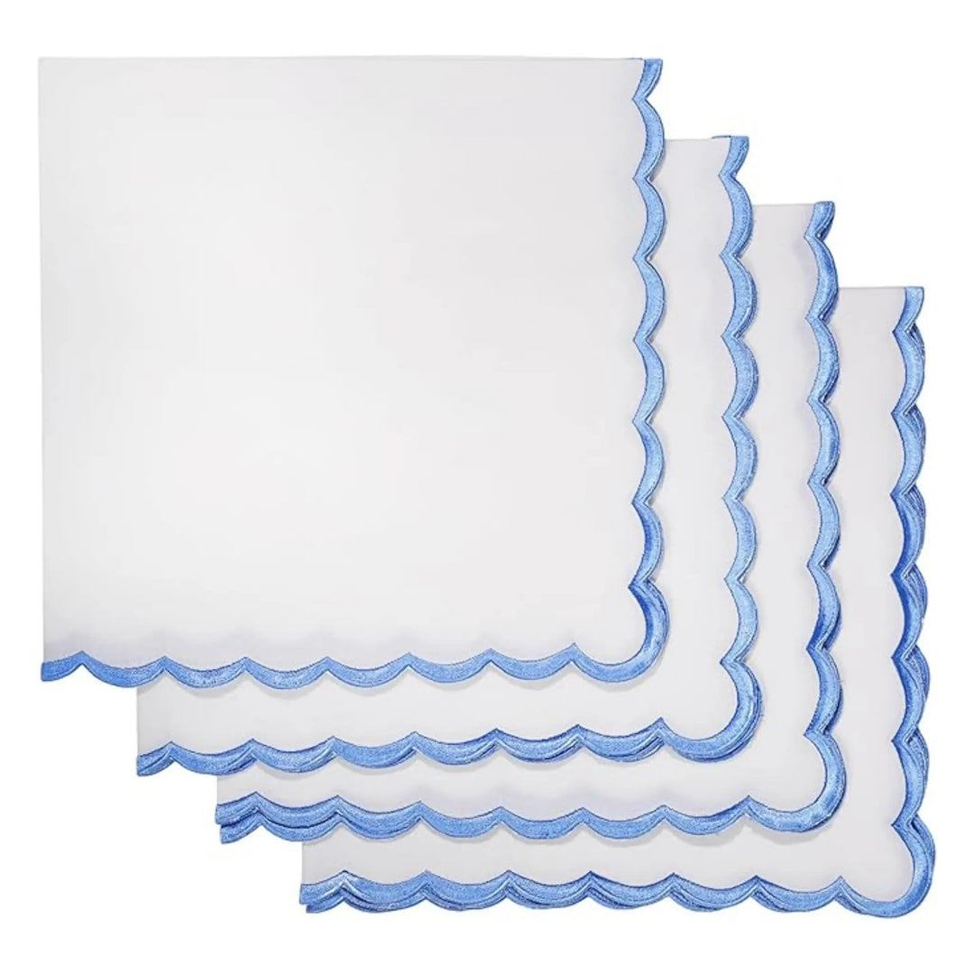 Set of white napkins with blue scalloped edges on a white background