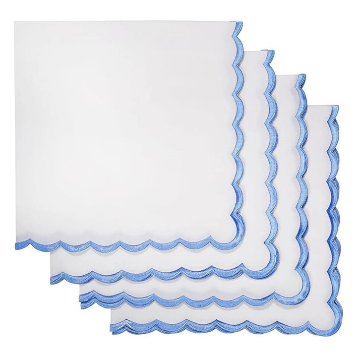 Set of white napkins with blue scalloped edges on a white background